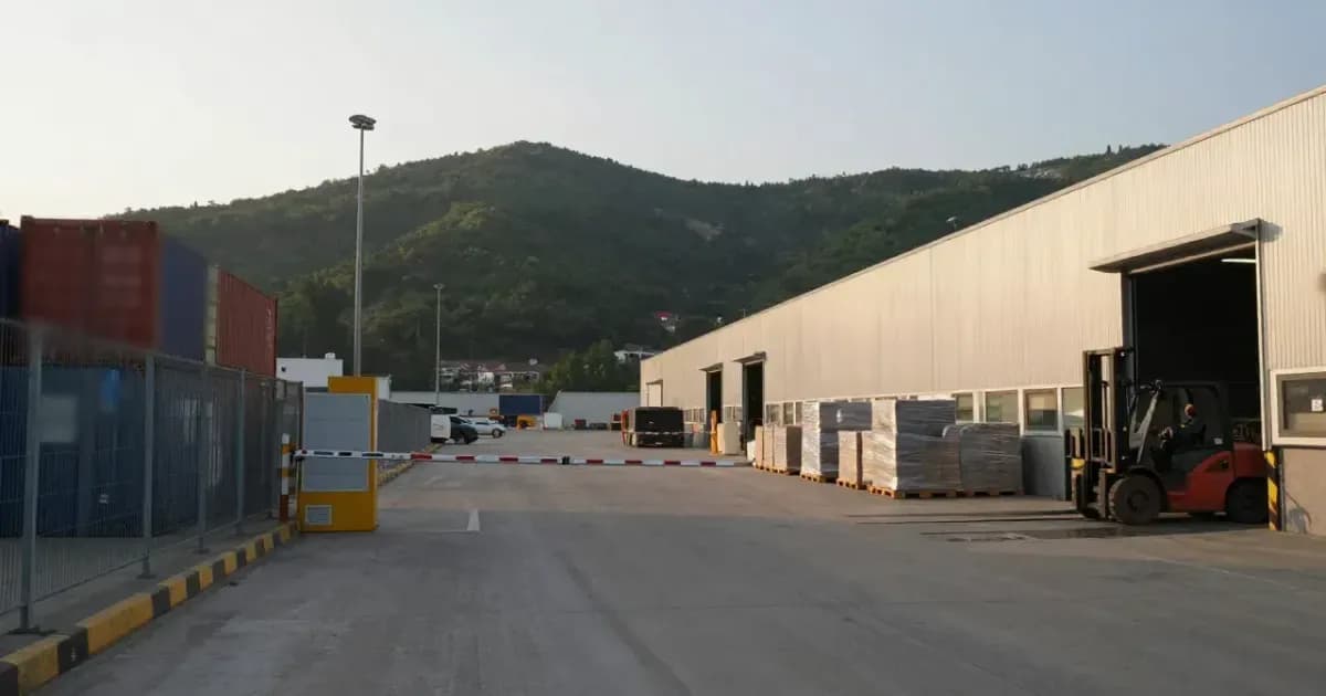Liman sahasında konteynerler, bariyerli giriş ve paletlerin yüklendiği depo rampası (temsili görsel)